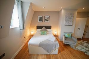 a bedroom with a large bed and a chair at Prince Street Studios in Bristol