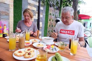 a man and a woman sitting at a table with food at Bean Grass Homestay in Hoi An