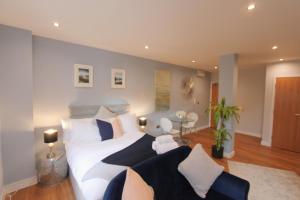 a bedroom with a white bed with blue and white pillows at Prince Street Studios in Bristol