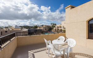 a balcony with white chairs and a table on a building at BLUESEA Costa Teguise Gardens in Costa Teguise