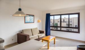 a living room with a couch and a window at BLUESEA Costa Teguise Gardens in Costa Teguise
