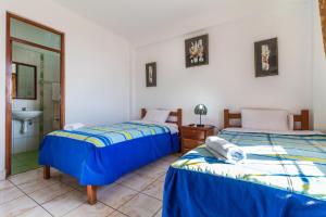 2 camas en una habitación con lavabo y espejo en Paracas Hotel Ballestas Island, en Paracas