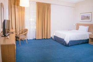 a hotel room with a bed and a television at Travohotel Monterrey Histórico in Monterrey