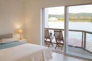 a bedroom with a bed and a balcony with a view at Beach House Antigua in Jolly Harbour