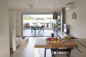 a kitchen and dining room with a table with a bowl of fruit at Beach House Antigua in Jolly Harbour +13 photos