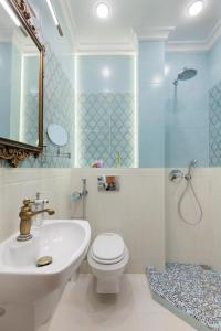 a bathroom with a sink and a toilet and a mirror at LUXOVSKI apartment in Lviv