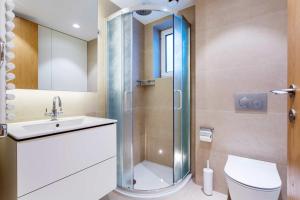 a bathroom with a shower and a toilet and a sink at Veeve - Mews and Majesty in Mayfair in London