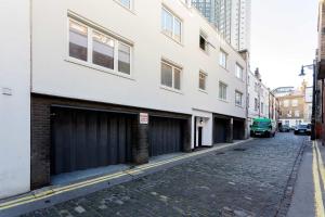 an empty street with two garages on the side of a building at Veeve - Mews and Majesty in Mayfair in London