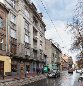 a street with buildings and a car on a rainy street at LUXOVSKI apartment in Lviv