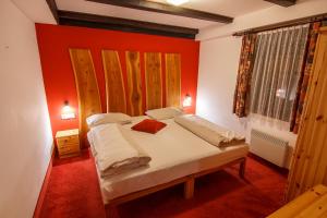 a bedroom with a bed with an orange wall at Alpenhotel Marcius in Sonnenalpe Nassfeld