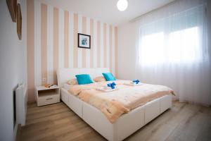 a bedroom with a white bed with blue pillows at Guest house PiN in Laktaši