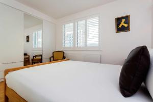 ロンドンにあるVeeve - Mews and Majesty in Mayfairの白いベッドルーム(ベッド1台、窓2つ付)