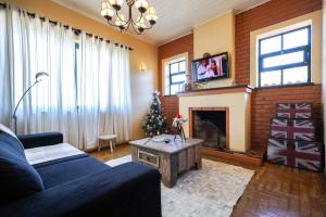 a living room with a couch and a fireplace at Mala & Tudo Pousada in Torres