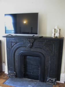 a black fireplace with a television on top of it at McBayne House in Hamilton