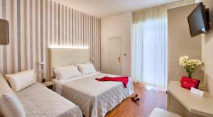 ein Hotelzimmer mit 2 Betten und einem TV in der Unterkunft Hotel Bremen in Rimini