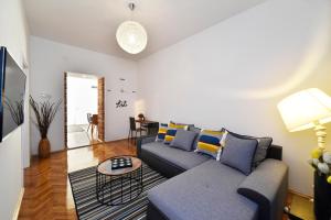 een woonkamer met een bank en een tafel bij Corner Apartments Savska in Zagreb