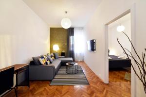 uma sala de estar com um sofá e uma mesa em Corner Apartments Savska em Zagreb