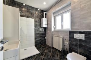 een badkamer met een wastafel en een toilet en een raam bij Corner Apartments Savska in Zagreb +29 foto's