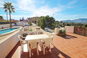 ベニッサにあるEl Ventorrillo - holiday home with stunning views and private pool in Benissaのパティオ(テーブル、椅子付)、プールが備わります。