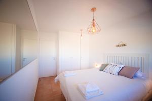 - une chambre avec un grand lit blanc et un éclairage dans l'établissement Paraiso II SS FREE WIFI, à Playa Paraiso