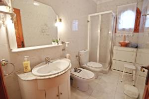 ein Badezimmer mit Waschbecken, Toilette und Spiegel in der Unterkunft El Ventorrillo - holiday home with stunning views and private pool in Benissa in Benissa