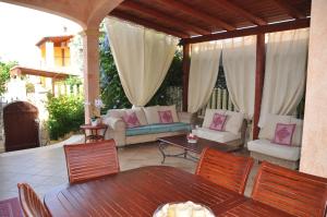 un patio esterno con tavolo e sedie di Villa Eva Luxury Villasimius a Villasimius