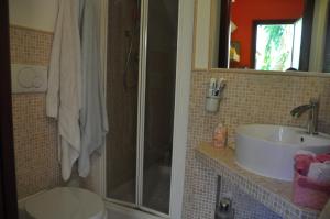 a bathroom with a shower and a sink and a toilet at Villa Eva Luxury Villasimius in Villasimius
