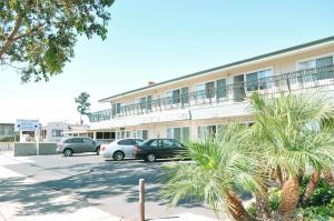 a building with cars parked in a parking lot at Crystal Lodge Motel in Ventura