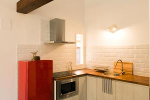 a kitchen with a red refrigerator and a sink at Denia Loft in Denia