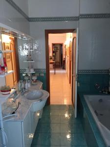 a bathroom with two sinks and a tub and a mirror at B&B DONNA PORZIA in Trani