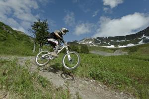 a man riding a bike on a dirt trail at Alyeska Resort in Girdwood