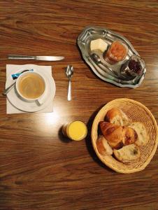 een tafel met een kom brood en een kopje koffie bij L'Hôtel du Mouton blanc in Fresne-Saint-Mamès