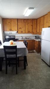 cocina con mesa y nevera blanca en Sonoma Lodge, en Bend