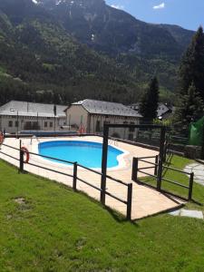 une grande piscine dans un champ avec une clôture dans l'établissement PASEO DE LOS AYERBE Nº5, à Canfranc-Estación