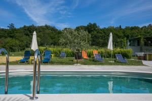 a group of chairs and umbrellas next to a pool at Kamp Romantik - glamping in Labin +14 photos