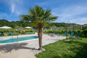 a palm tree sitting next to a swimming pool at Kamp Romantik - glamping in Labin
