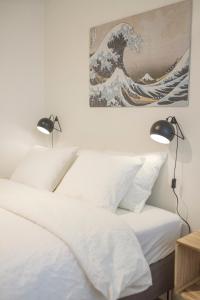 a bedroom with two lamps and a painting on the wall at Functional housings 2 steps from Grand Place in Brussels