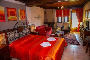 1 dormitorio con cama roja y sala de estar en Aenao, en Neochori