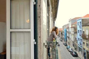 Una mujer está montando una bicicleta en un balcón en Downtown Porto Spot - 2 bedrooms, en Oporto