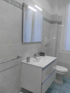 a white bathroom with a sink and a toilet at House Procaccini, 20 in Bologna