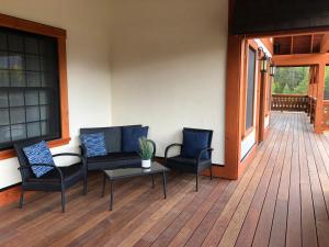 un porche con 2 sillas y una mesa en una terraza en Great Northern Resort (Lodge) en West Glacier