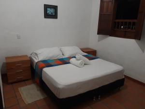 a bedroom with a bed with two towels on it at Casa Doña Rosaura Barichara ALQUILER Entero in Barichara