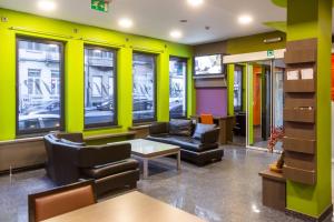 a waiting room with a couch and chairs and windows at Wellness Apart Hotel in Brussels