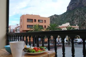 a plate of food on a table on a balcony at Hostal Casa Amaya in Vallehermoso