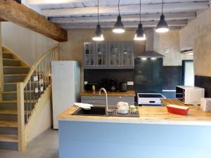 a kitchen with a counter with a sink and a refrigerator at la grange de clotilde in Siguer