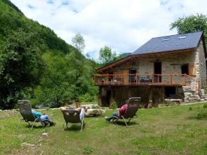 un groupe de personnes assises sur des chaises devant une maison dans l'établissement la grange de clotilde, à Siguer