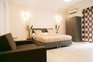 a bedroom with a bed and a couch and a chair at J PAD in Dakar