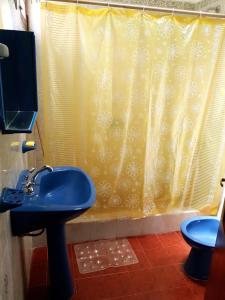 a bathroom with a blue sink and a shower curtain at Hopedaje Felisa in Cafayate