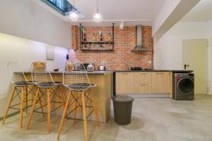 a kitchen with a bar with chairs and a brick wall at athensotel in Athens