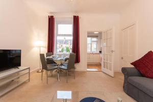 a living room with a table and a couch at Glebe Street Apartment in Fife
